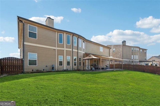 rear view of house with a lawn and a patio area