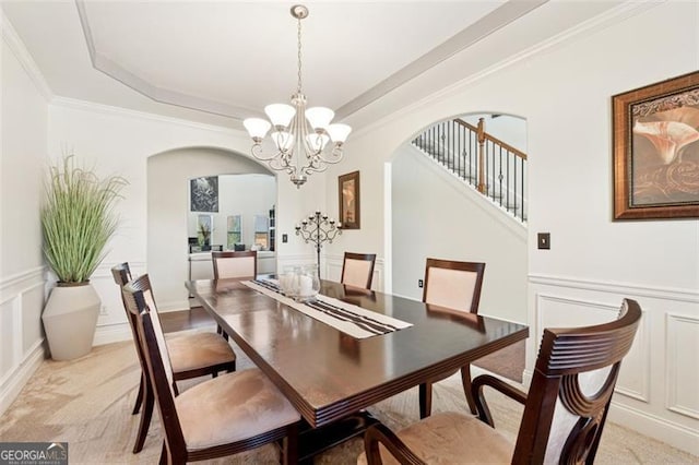 dining space featuring crown molding, light carpet, an inviting chandelier, and a tray ceiling