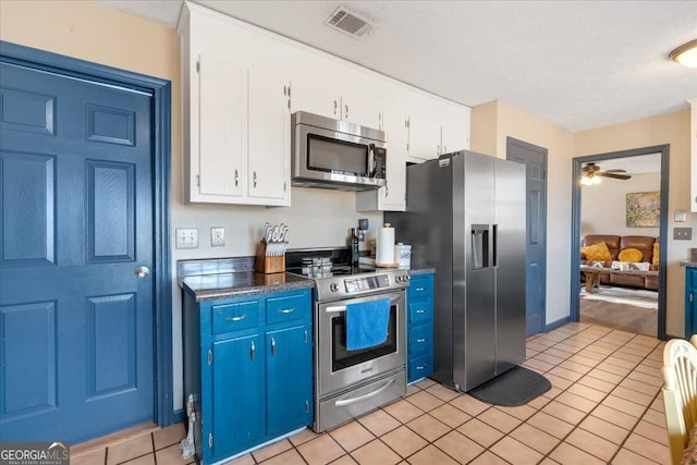 kitchen featuring white cabinetry, stainless steel appliances, a textured ceiling, and light tile patterned floors