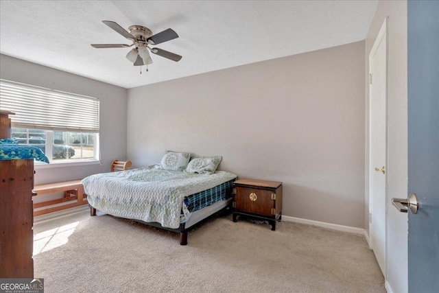 carpeted bedroom featuring a textured ceiling and ceiling fan