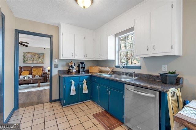 kitchen with white cabinetry, stainless steel dishwasher, blue cabinets, and sink