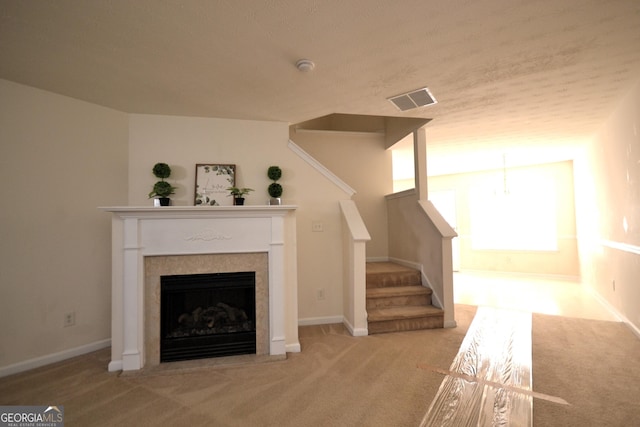 unfurnished living room featuring light colored carpet and a textured ceiling