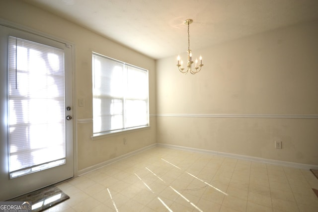 unfurnished dining area featuring an inviting chandelier