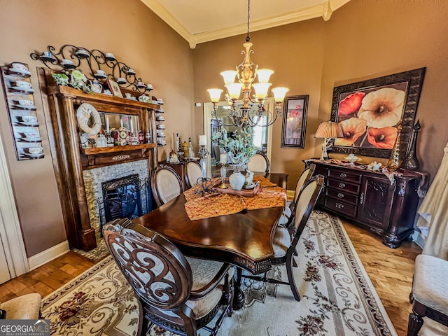 dining room featuring a tiled fireplace, a notable chandelier, crown molding, and light hardwood / wood-style flooring