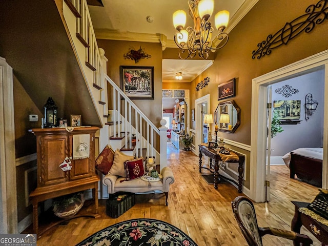 entrance foyer featuring hardwood / wood-style flooring, ornamental molding, and an inviting chandelier