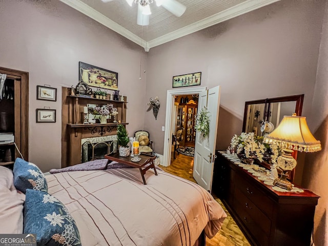 bedroom featuring ornamental molding, wood-type flooring, a textured ceiling, and ceiling fan