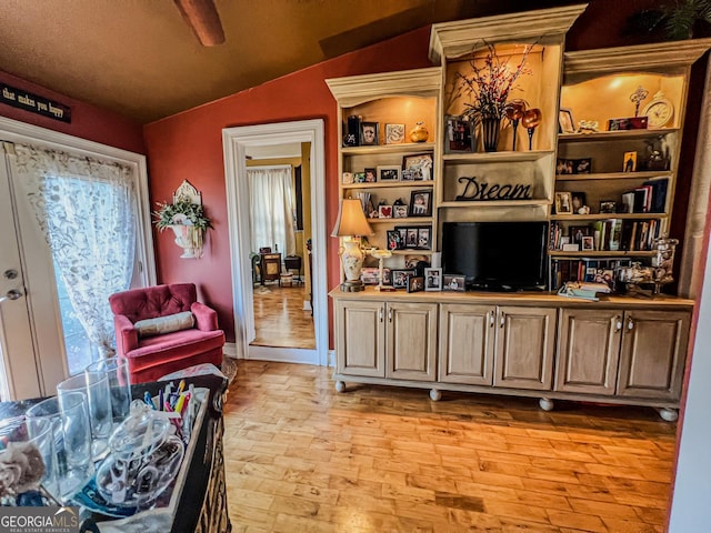 living room featuring lofted ceiling and light hardwood / wood-style floors