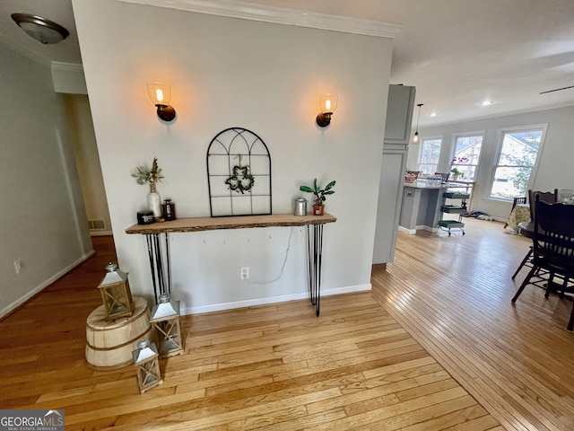 corridor featuring crown molding, light wood finished floors, recessed lighting, visible vents, and baseboards