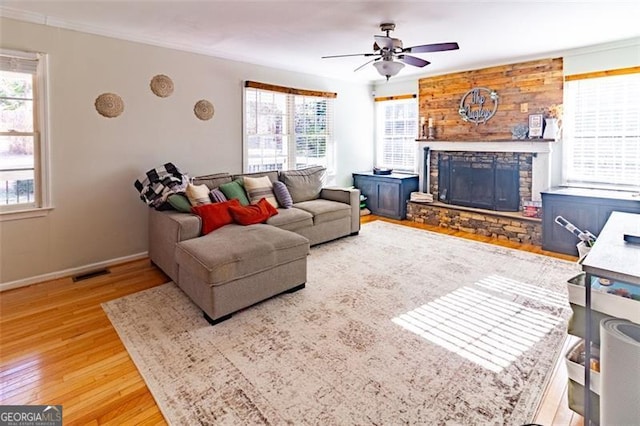 living room featuring a fireplace, wood-type flooring, and ceiling fan