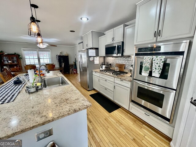 dining space with ceiling fan, ornamental molding, and light hardwood / wood-style flooring