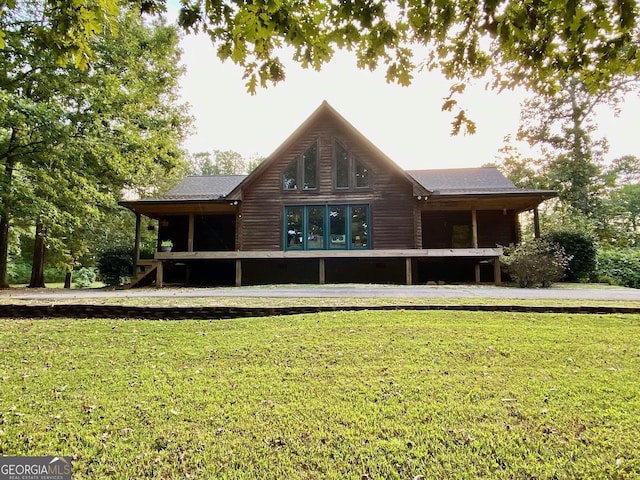 rear view of house featuring a lawn