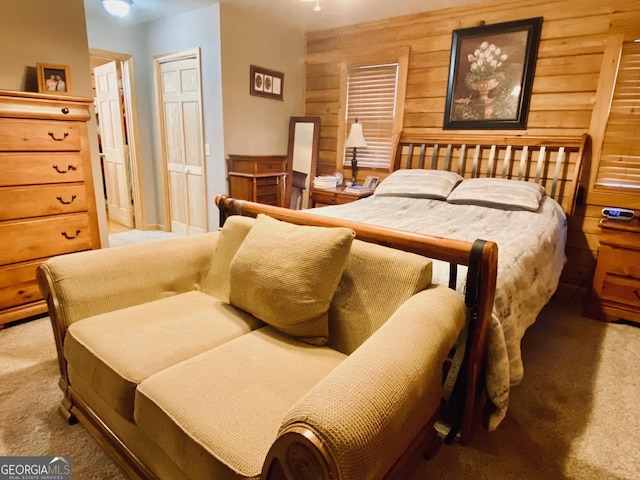 bedroom with wooden walls and carpet flooring