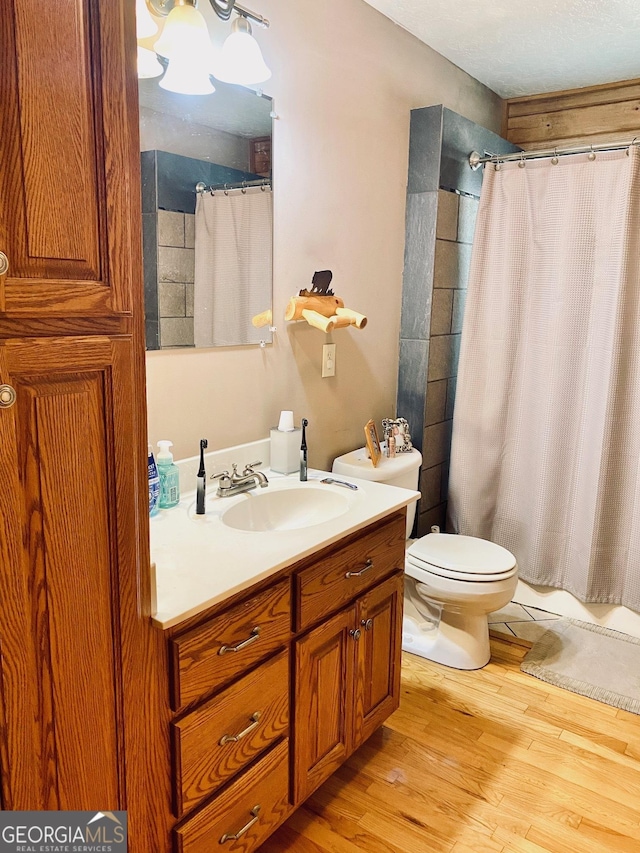 bathroom featuring wood-type flooring, vanity, and toilet