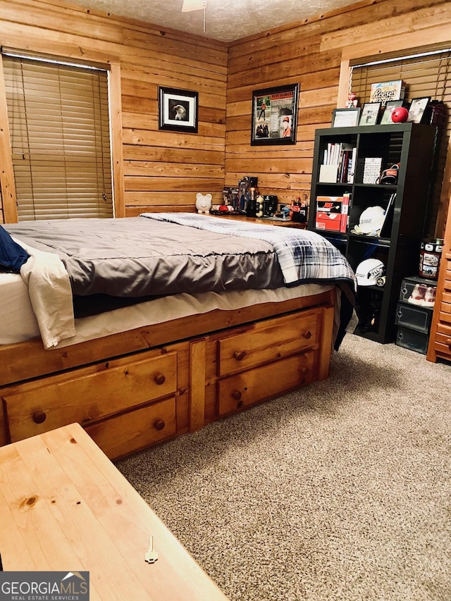 bedroom featuring carpet and wooden walls