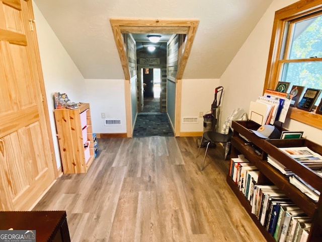 additional living space with lofted ceiling and hardwood / wood-style flooring