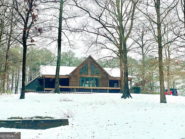 view of snow covered back of property