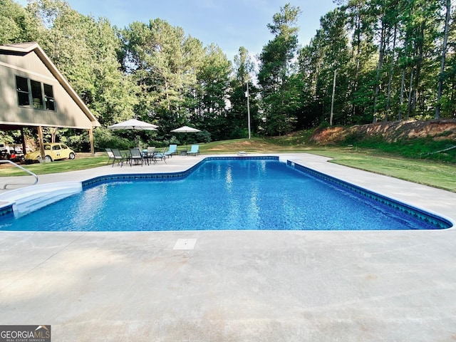 view of pool featuring a yard and a patio area