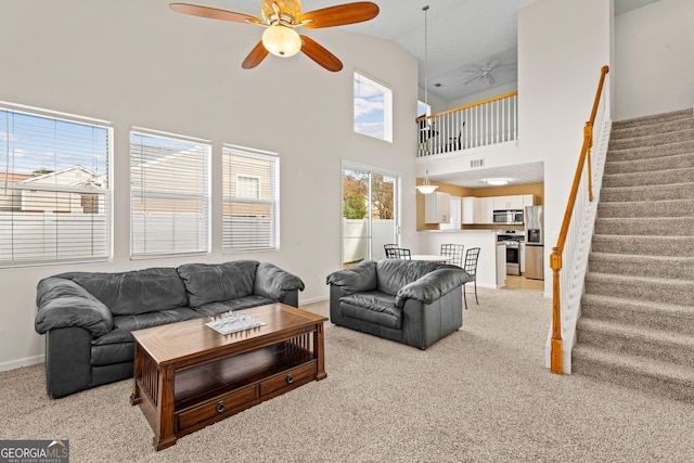 carpeted living room featuring high vaulted ceiling and ceiling fan