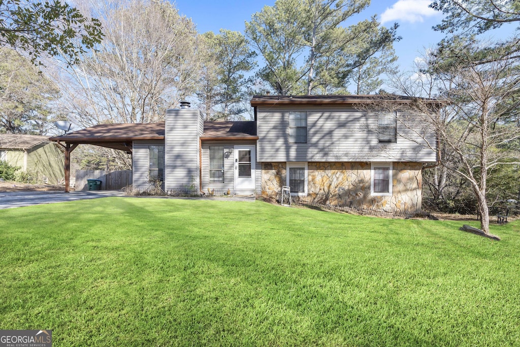 rear view of house with a carport and a lawn