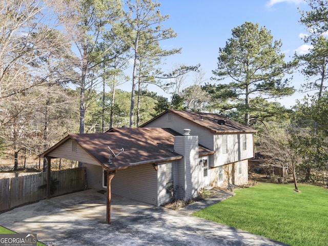 view of side of property featuring a carport and a yard