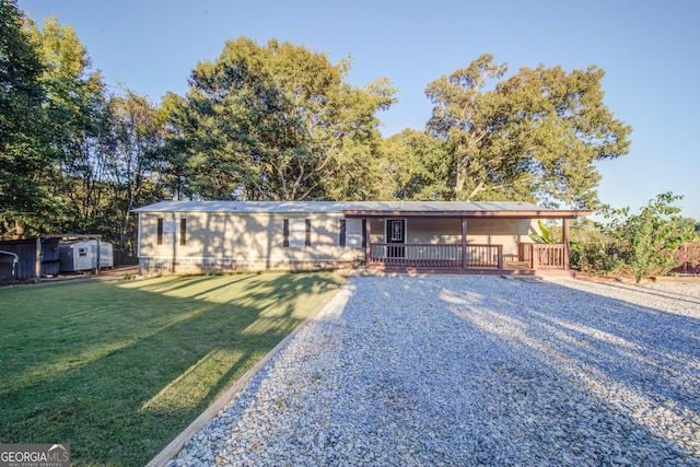 ranch-style house featuring a wooden deck and a front yard