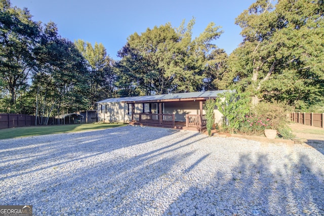 view of front facade featuring a wooden deck and a front yard