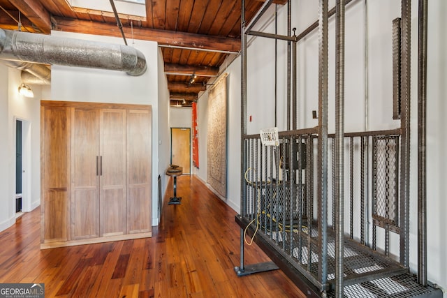 hall with wooden ceiling, beam ceiling, baseboards, and hardwood / wood-style flooring