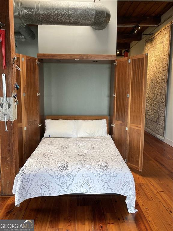 bedroom with wood ceiling, beamed ceiling, and wood finished floors