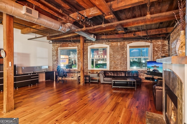 living area featuring visible vents, wood ceiling, brick wall, hardwood / wood-style floors, and beam ceiling