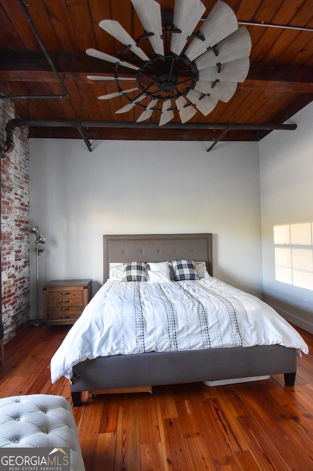 bedroom with wooden ceiling, brick wall, beamed ceiling, and hardwood / wood-style floors