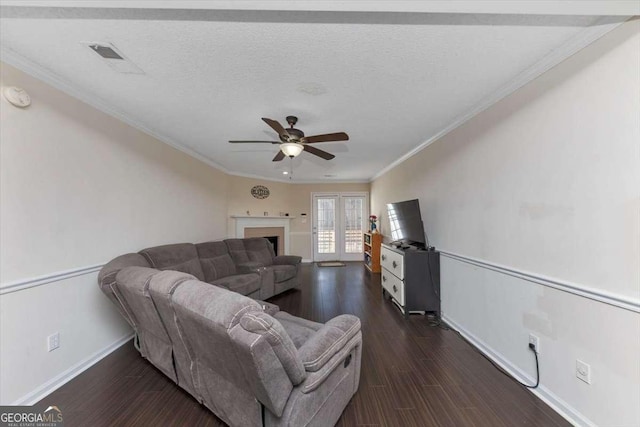 living room featuring ceiling fan, crown molding, dark hardwood / wood-style floors, and a textured ceiling