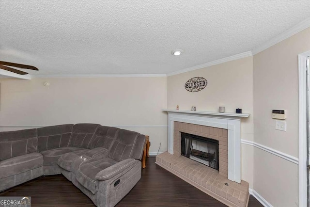 living room with hardwood / wood-style flooring, ornamental molding, a brick fireplace, and ceiling fan