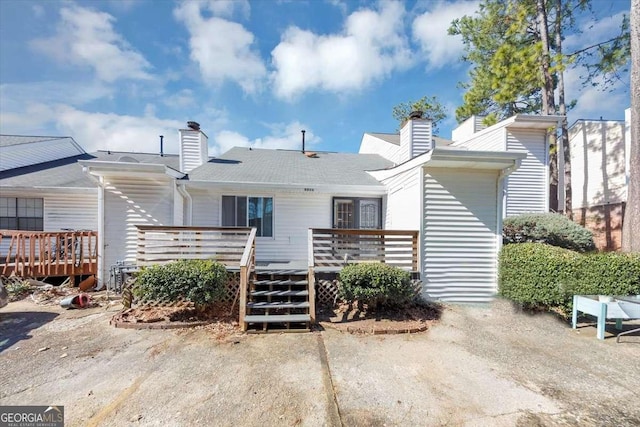 rear view of property featuring a wooden deck