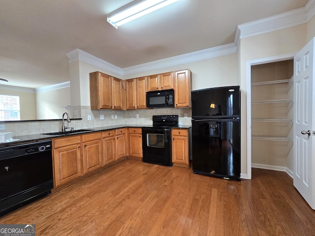 kitchen featuring backsplash, wood-type flooring, sink, and black appliances