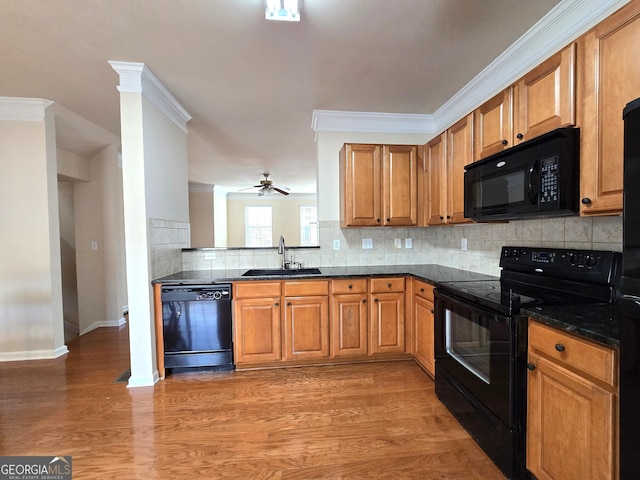 kitchen featuring sink, backsplash, light hardwood / wood-style floors, black appliances, and crown molding