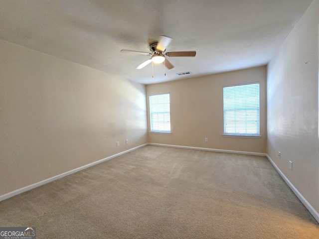 carpeted spare room featuring ceiling fan