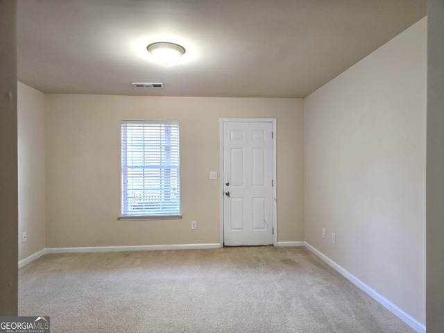 unfurnished room featuring light carpet