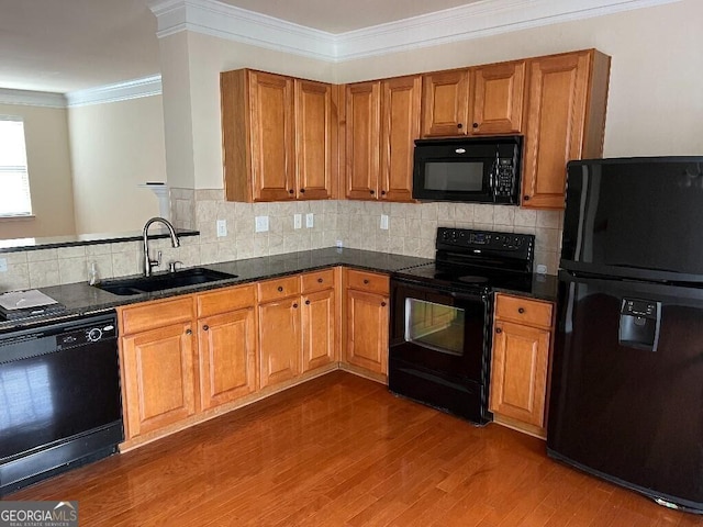 kitchen with sink, backsplash, ornamental molding, black appliances, and dark wood-type flooring