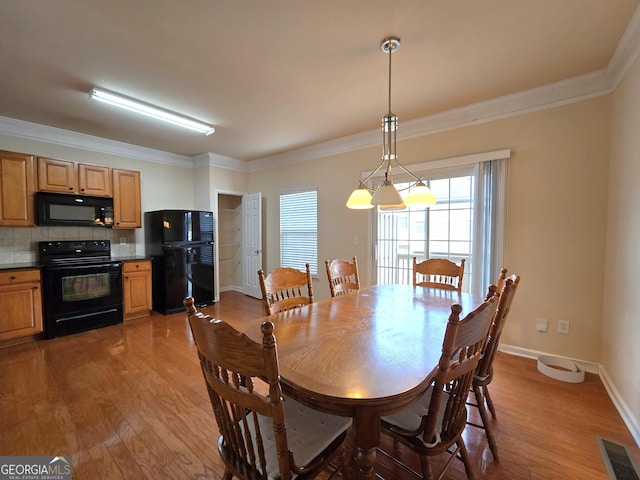 dining space featuring crown molding and light hardwood / wood-style flooring