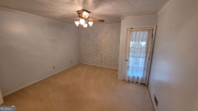 spare room featuring light carpet, a textured ceiling, ornamental molding, and ceiling fan