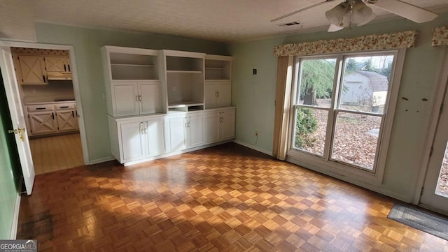 kitchen featuring white cabinets, ceiling fan, and light parquet floors