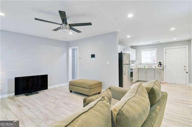 living room featuring ceiling fan and light wood-type flooring