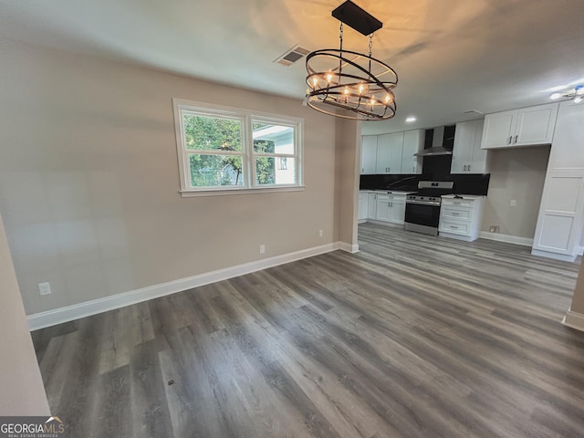 kitchen with white cabinetry, decorative light fixtures, electric range, hardwood / wood-style flooring, and wall chimney range hood