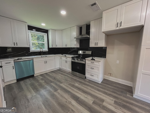 kitchen featuring white cabinetry, stainless steel appliances, sink, and wall chimney range hood