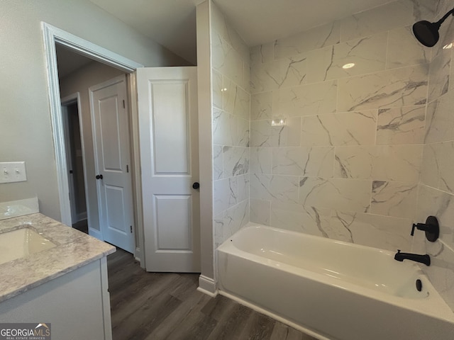 bathroom featuring hardwood / wood-style flooring, vanity, and tiled shower / bath