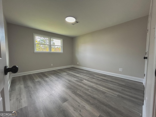 spare room featuring dark wood-type flooring