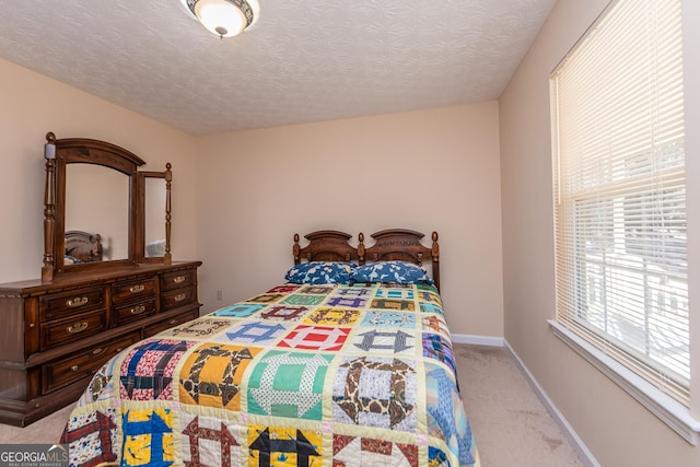 bedroom featuring light colored carpet and a textured ceiling