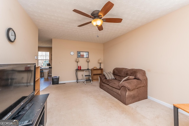 living room with ceiling fan, carpet floors, and a textured ceiling