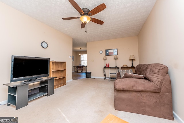 carpeted living room with ceiling fan with notable chandelier and a textured ceiling