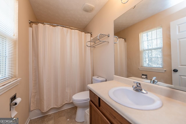 bathroom featuring vanity, tile patterned flooring, a textured ceiling, and toilet